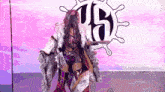a woman in a fur coat is standing in front of a sign that says tb .