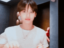 a man wearing a white shirt and a necklace