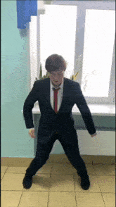 a man in a suit and tie is dancing on the floor