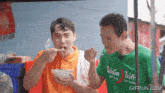 a man wearing a green shirt that says not eating is eating food from a bowl
