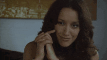 a woman is smiling with her hands folded