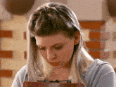 a woman with a braided hair style is looking down at something
