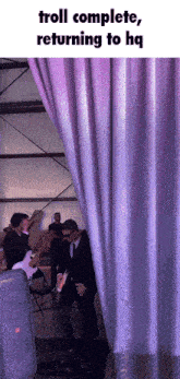 a man in a suit is standing behind a purple curtain with the caption troll complete returning to hq