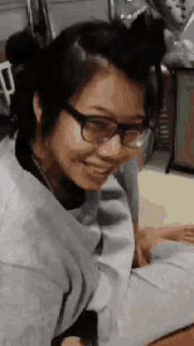 a woman wearing glasses is smiling for the camera .