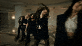 a group of women are dancing together in a dark room