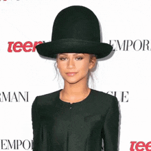 a woman wearing a black top hat is standing in front of a sign that says emporer