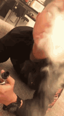 a man is laying on the floor smoking an electronic cigarette with smoke coming out of his mouth