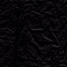 a piece of crumpled black paper with a white cross on it