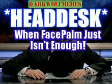 a man in a suit and tie is sitting at a desk with his head in his hands .