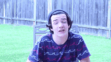 a young man wearing a beanie and a shirt with waves on it