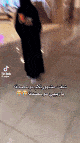 a tiktok video of a woman walking with arabic writing on the bottom
