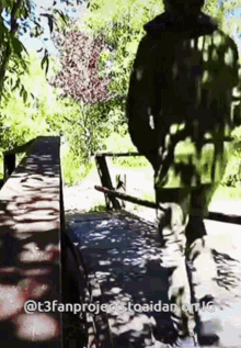 a man is walking across a bridge with a caption that says @ t3fanproject toaidan on ig