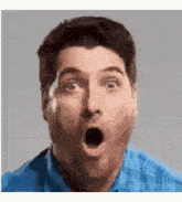 a man with a surprised look on his face is wearing a blue shirt .