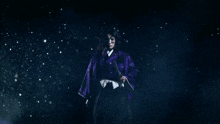 a man in a purple kimono stands in front of chinese characters