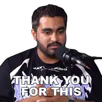 a man with a beard is sitting in front of a microphone saying thank you for this