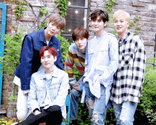 a group of young men are posing for a picture in front of a brick building