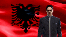 a man in a suit stands in front of a red flag with an eagle on it