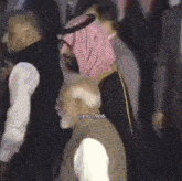 a group of men are standing in a crowd .