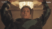 a poster for nine perfect strangers shows a woman looking up at a chandelier and asking what about me