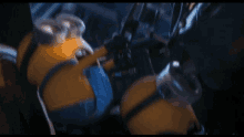 a close up of a yellow minion with a blue shirt and goggles