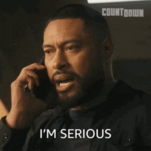 a man talking on a cell phone with the words i 'm serious written below him