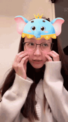 a woman wearing glasses and a blue and pink elephant mask