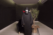 a person dressed in a grim reaper costume stands in a dark room
