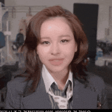 a close up of a woman wearing a suit and tie with foreign writing on the bottom