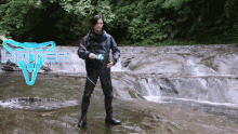 a man is standing in a stream with the word water behind him