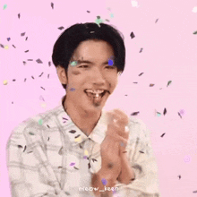 a man is smiling while confetti is falling around him .