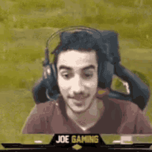 a man wearing headphones and a red shirt is sitting in a chair .