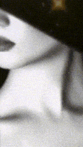 a black and white photo of a woman 's face with a blurred background .