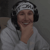 a person wearing headphones and a beanie that says ' nc le ' on it