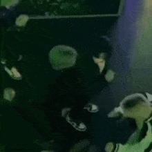 a group of people are dancing in a dark room .