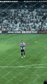 a soccer player stands on the field with a sign that says hersey degis bir sozunle