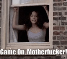 a woman is looking out of a window with the words game on motherfucker written on the bottom .