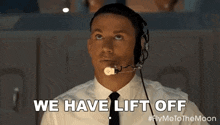 a man in a suit and tie is wearing a headset .