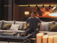 a man sits on a couch with a chess board on the table