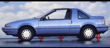 a blue car is sitting on red cones in the water
