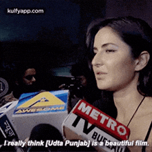 a woman is talking to a reporter while holding a metro tv bulletin .