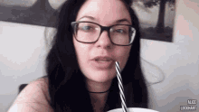 a woman wearing glasses is drinking through a straw and the name alice is on the bottom