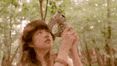 a woman is holding a camera that has the letter o on it