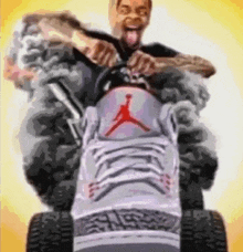 a man is riding a lawn mower made out of a pair of air jordan shoes .