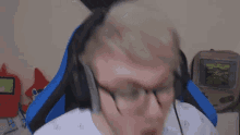 a man wearing glasses and headphones is sitting in a chair .
