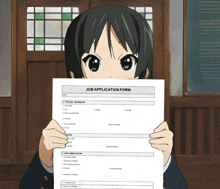 a girl is holding up a job application form in front of her face