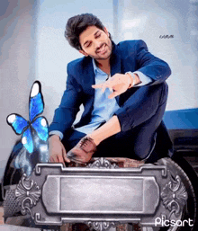 a man in a suit is squatting down next to a butterfly and a sign that says piesart