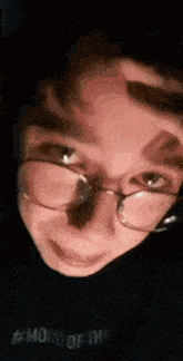 a close up of a person wearing glasses and a black shirt that says mood of the .