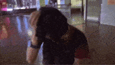 a man in a black shirt holds his head in his hands