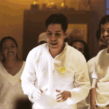 a man in a white shirt has a yellow button on his chest that says red gif