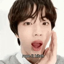 a young man is making a funny face and saying `` rope it bitch '' with his tongue out .